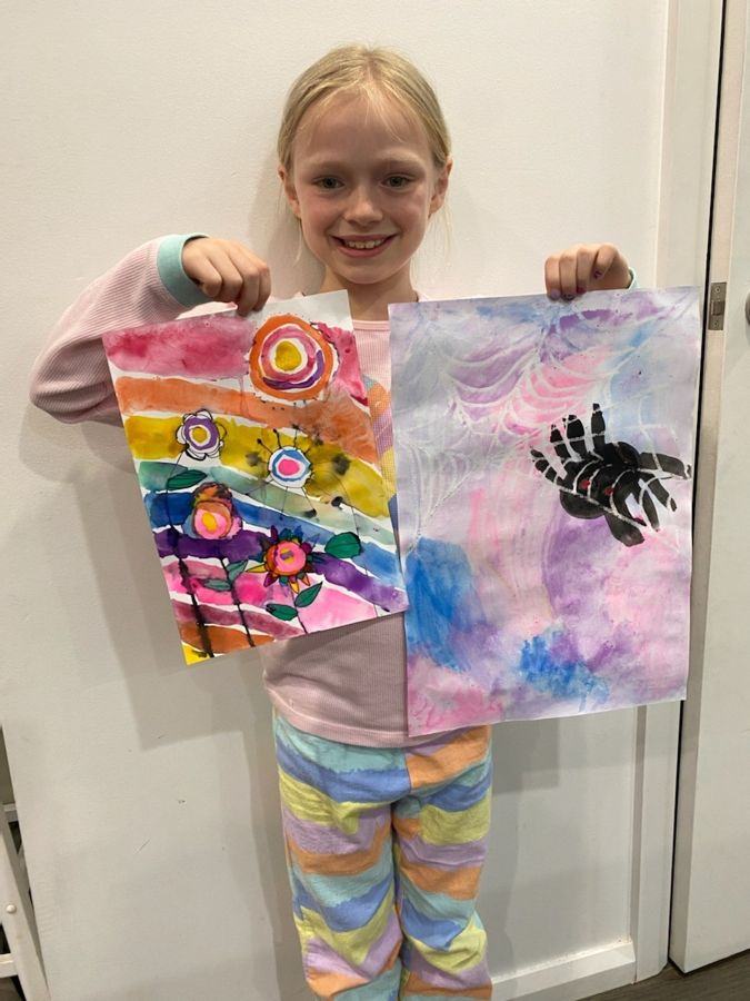 Two girls holding their mosaic heart artworks