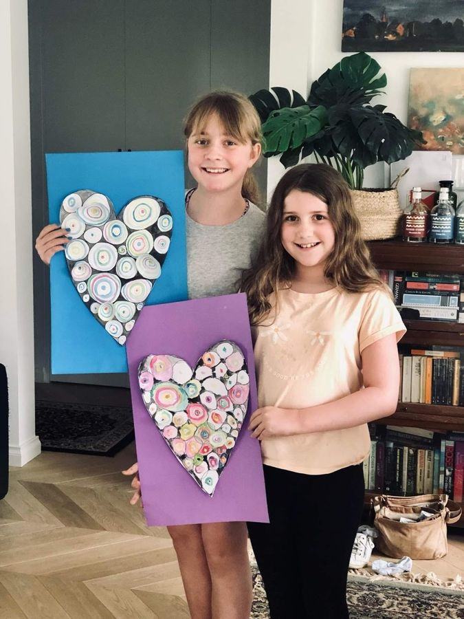 Two girls holding their mosaic heart artworks