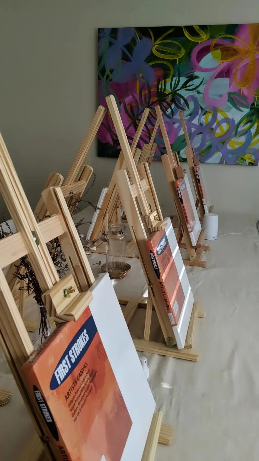 Rows of easels set up with canvases in Ros's art studio
